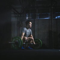 ジムで重量挙げに集中する男性の瞬間、バーベルを持ちトレーニング中の写真