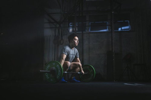 ジムで重量挙げに集中する男性の瞬間、バーベルを持ちトレーニング中