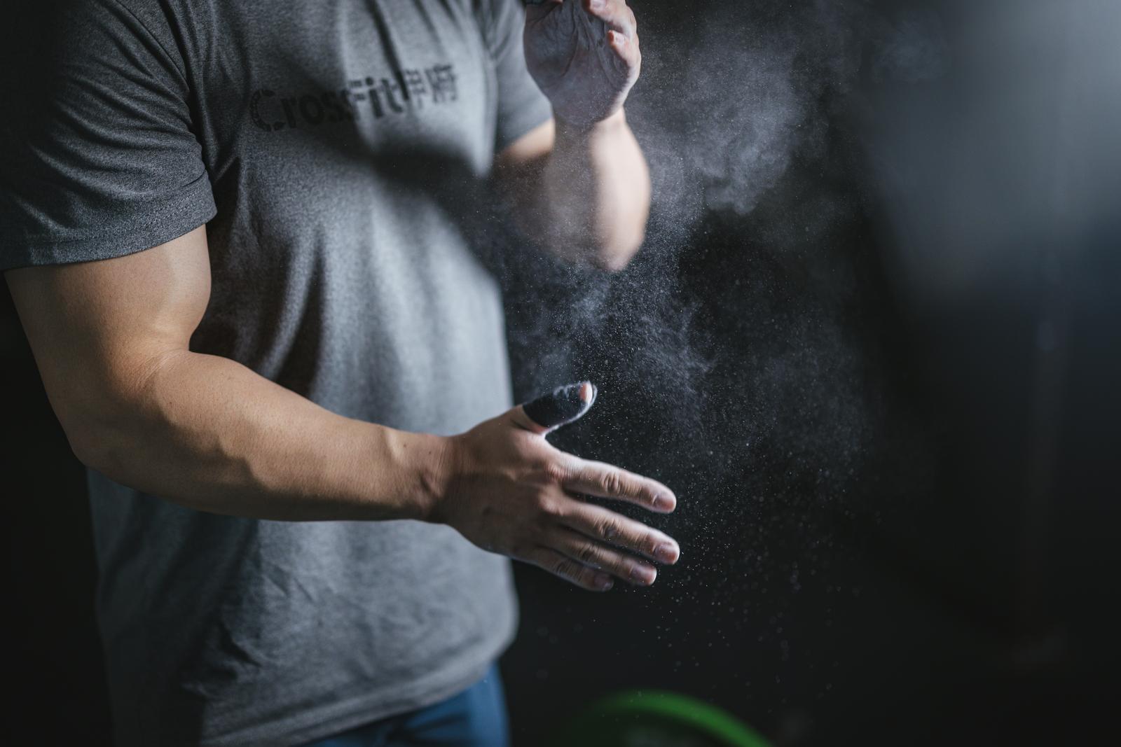 グレーのTシャツを着た男性が両手に白い粉をつけている［モデル：鈴木秀］