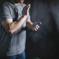 ジムでのトレーニング前に滑り止めと粉末を準備する男性の写真