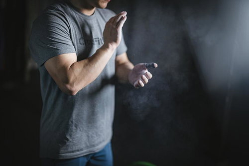 ジムでのトレーニング前に滑り止めと粉末を準備する男性