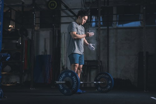 滑り止めをつけてバーベルを持ち上げる男性