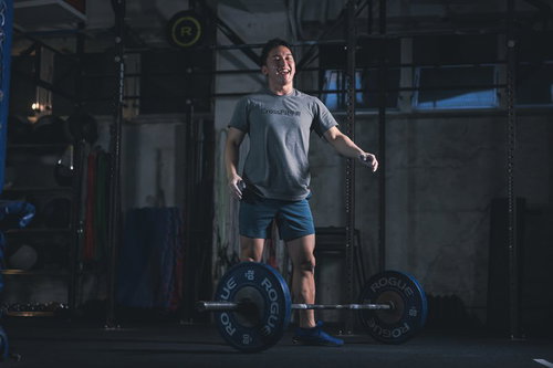 ウエイトリフティングのセット数をクリアして笑顔を見せる男性