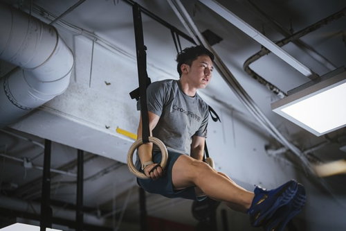 つり革につかまり脚を上げて行うファンクショナルトレーニング