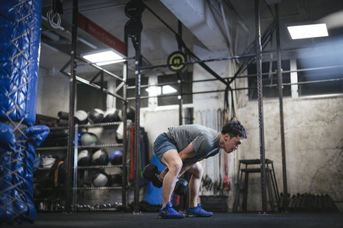 ダンベルでフィジカルを向上させるトレーニング中の男性