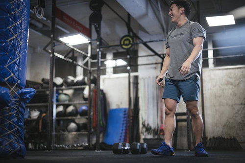 ジムでダンベルトレーニング中のマッスル経営者