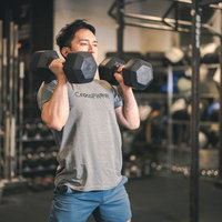 ジムでダンベルを使ったウエィトトレーニングを行う男性の写真