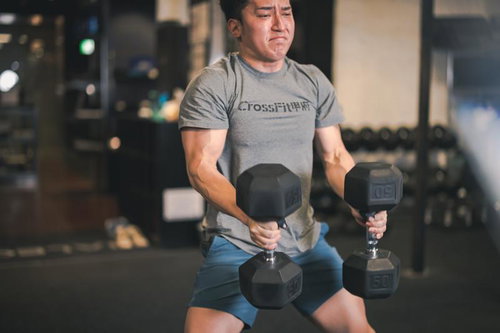 ダンベルトレーニングで無敵の体を手に入れる男性