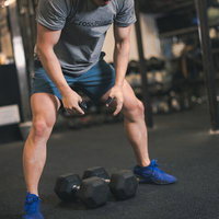ジムでダンベルトレーニングをする男性の筋トレ風景の写真