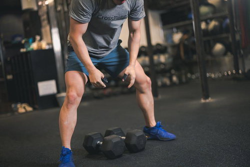 ジムでダンベルトレーニングをする男性の筋トレ風景