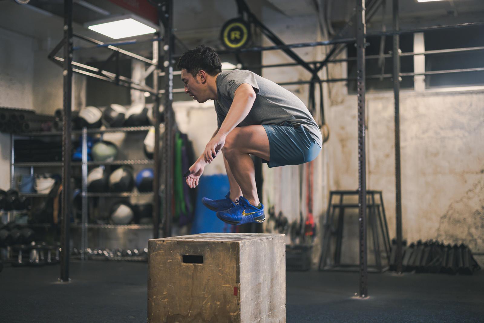 ボックスの上でジャンプを繰り返すファンクショナルトレーニング中の男性［モデル：鈴木秀］