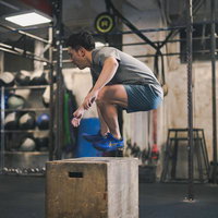 ボックスジャンプで行うファンクショナルトレーニングを繰り返す男性の写真