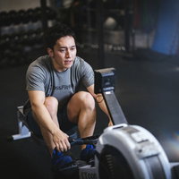 ローイングマシンでトレーニングを行う男性アスリートの写真