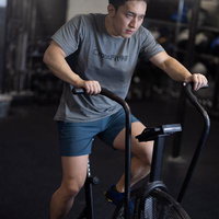 ジムでエアバイクを使用する男性のクロストレーナーの写真