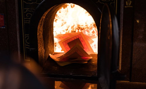 春節に関帝廟で金紙を焚き上げする参拝風景