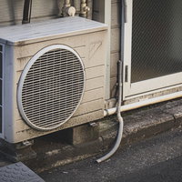 古い室外機がガタガタと音を立てる劣化した空調設備の写真