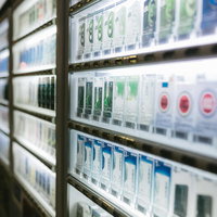 ガラスケースに並ぶ煙草の自動販売機の商品陳列風景の写真