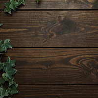 木目調のテーブルに伸びる緑の蔦のテクスチャーの写真