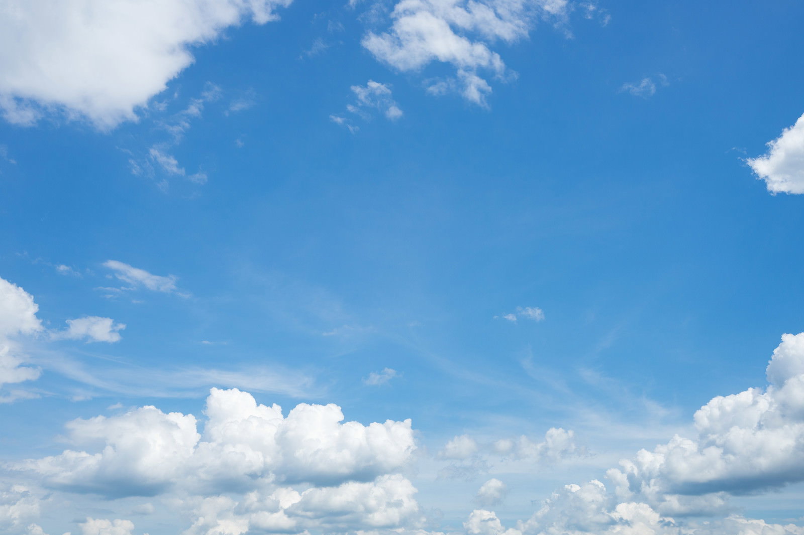 青空に白い雲がいくつも浮かんでいる爽やかな空の風景