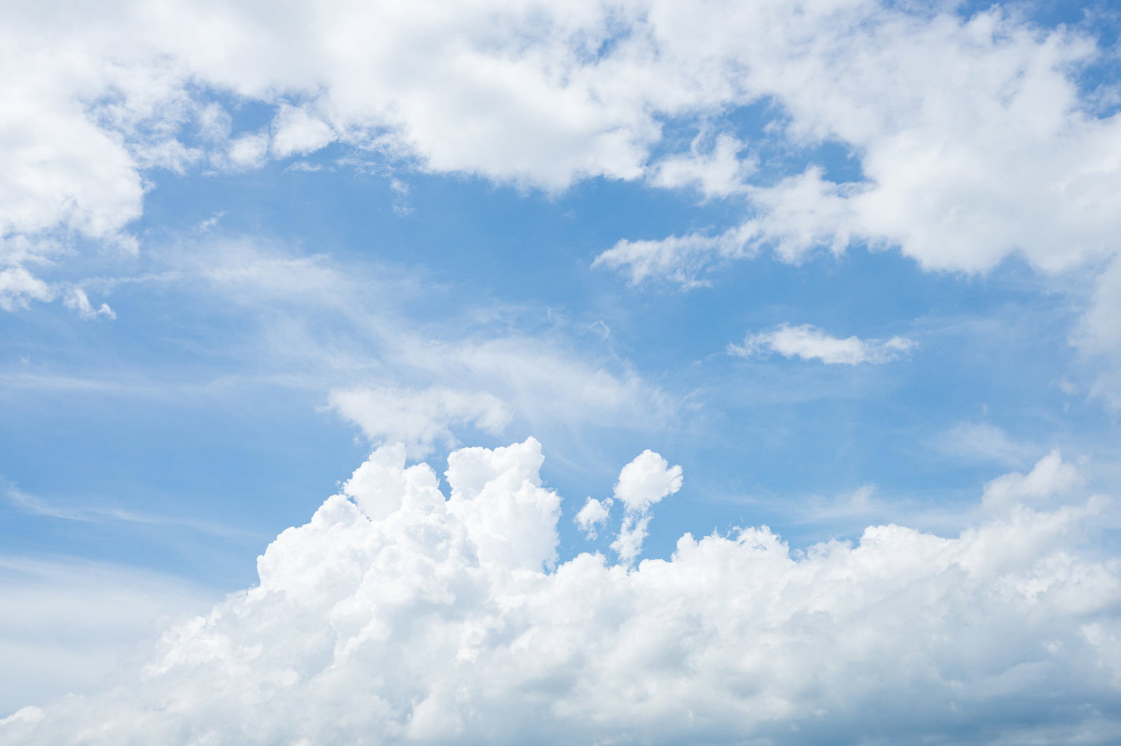 青空に大きな白い雲が浮かんでいる晴天の空
