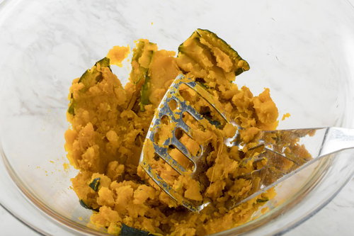 やわらかくなったカボチャをマッシャーで潰す調理シーン