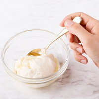 スプーンで垂らすクリームチーズとはちみつの写真