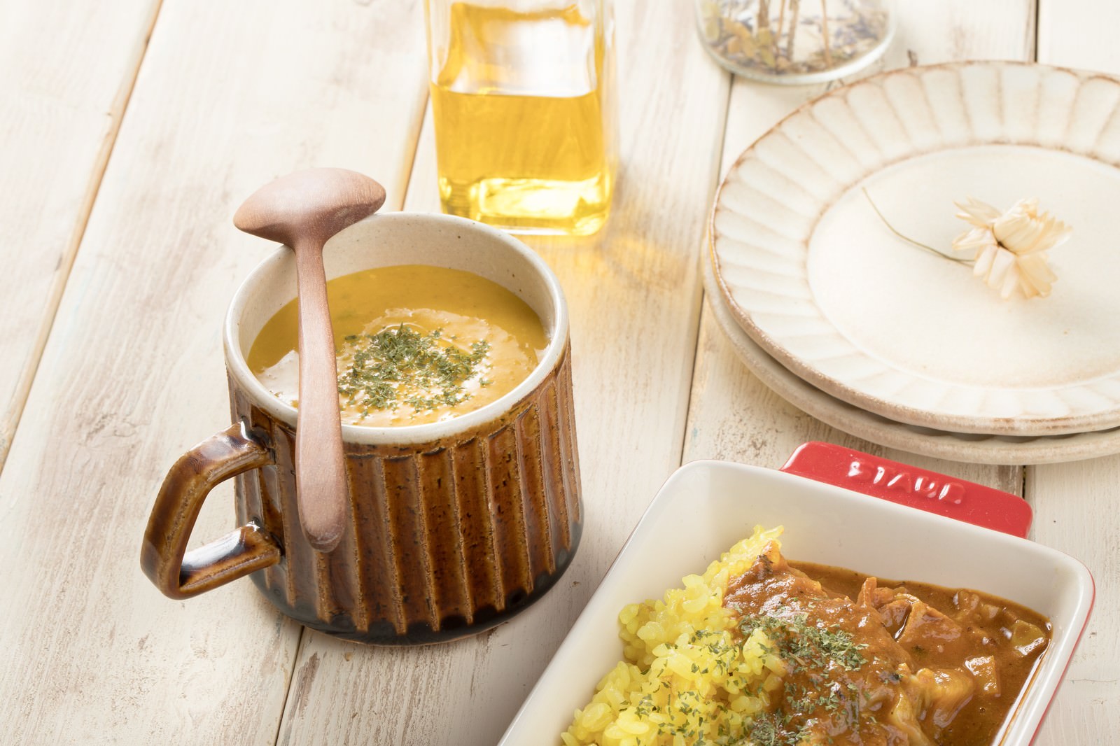 マグカップに入ったかぼちゃのポタージュとカレーライスを並べた食卓