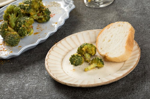 フランスパンとブロッコリーの唐揚げ、木製の皿に盛り付け