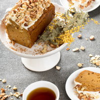 白いケーキスタンドに乗ったにんじんケーキと紅茶の写真