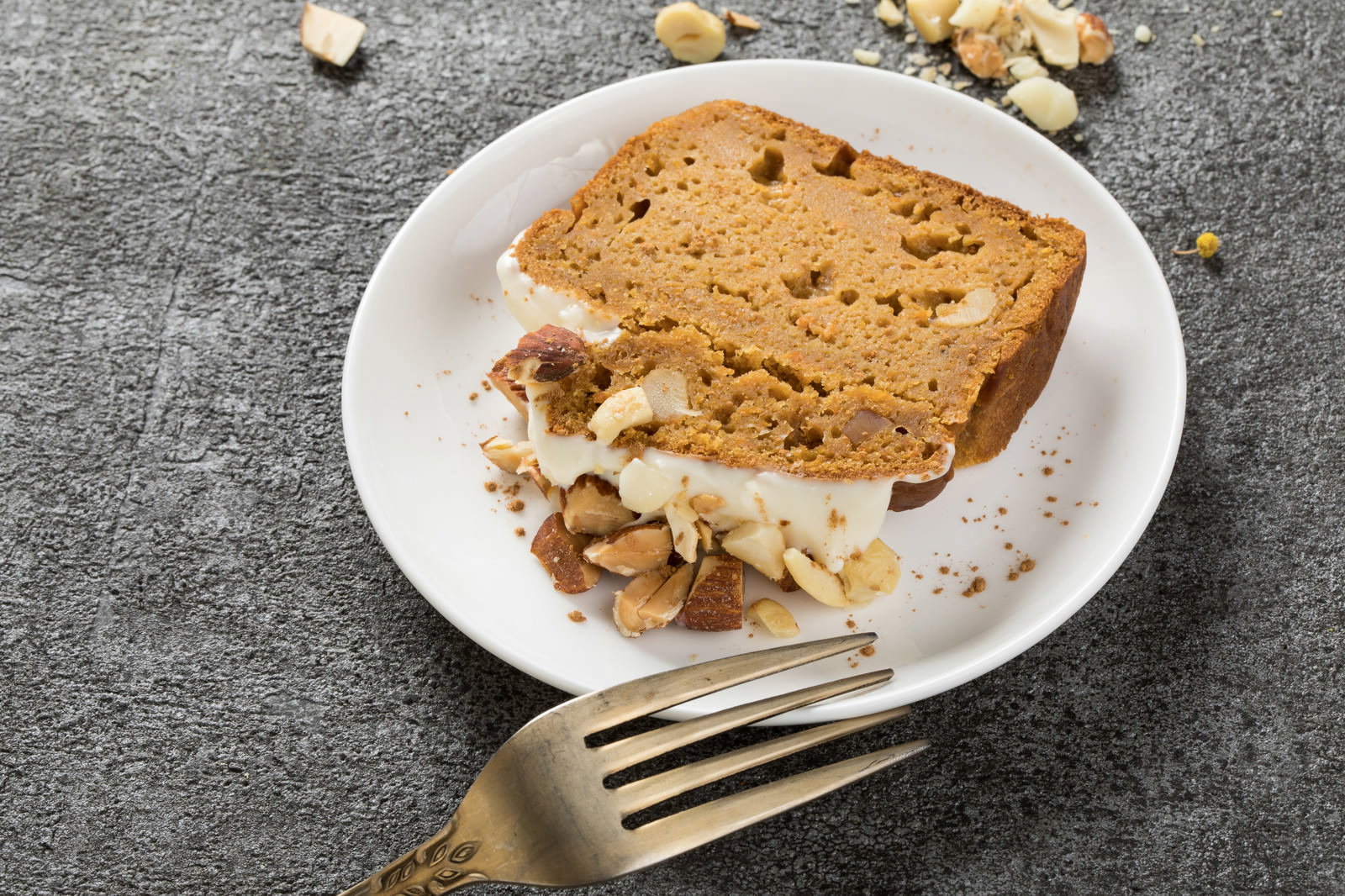 白いお皿に盛り付けられた米粉とおからのにんじんケーキとフォーク