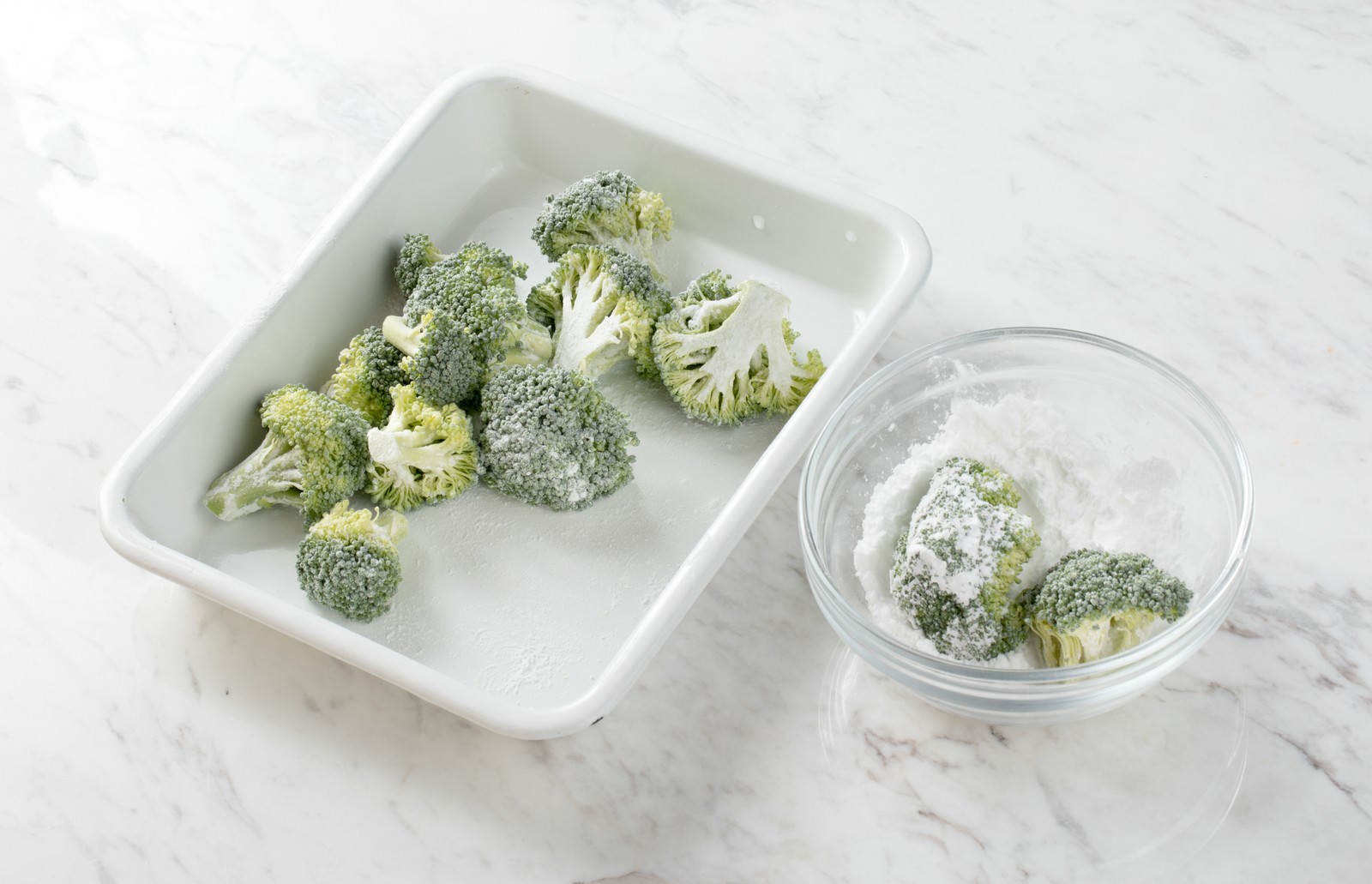 白い容器と透明なボウルに入った米粉をまぶしたブロッコリー