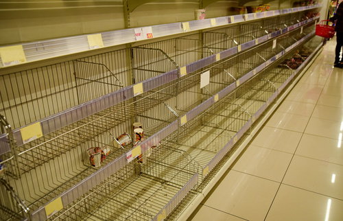 台風や災害時のスーパーの棚が品切れ状態になった売場の風景