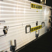 川の氾濫に備えて防水板を設置中の防災対策の写真