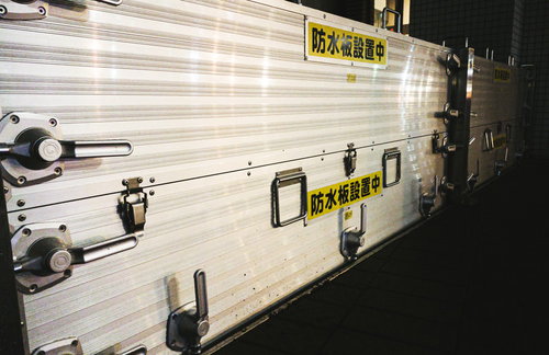 川の氾濫に備えて防水板を設置中の防災対策