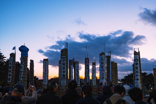 夕焼け空に立ち並ぶ松明あかしの火祭り、須賀川市
