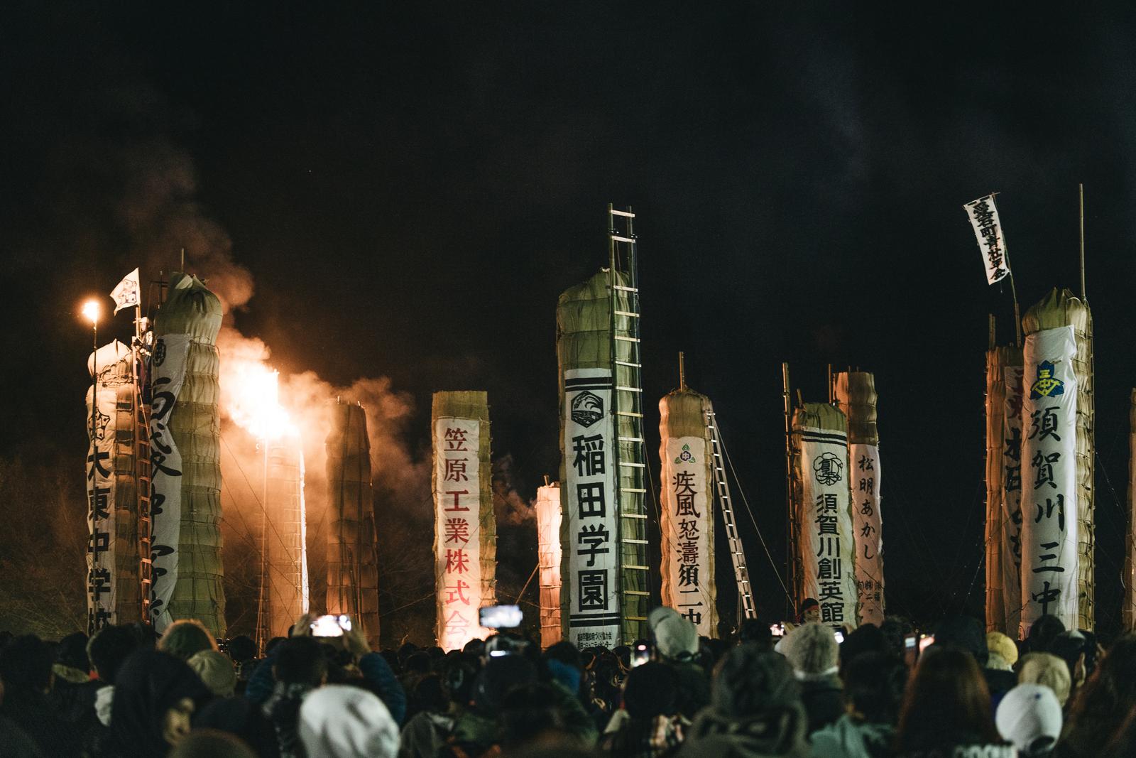 夜間に火が着けられて炎が立ち上る須賀川市の松明あかし。複数の松明が立ち並ぶ様子