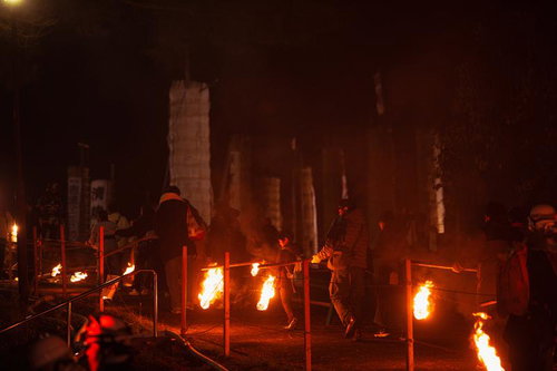 五老山をのぼる小松明行列の火の玉と松明祭りの炎