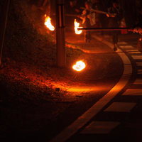 夜間の小松明行列で火の球が燃える松明あかしの炎の写真