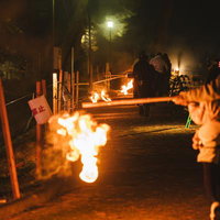 夜間に炎を奉納する小松明行列の火の玉と松明祭りの写真
