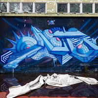 青いグラフィティが描かれた外壁の写真