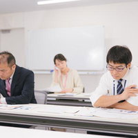 書類に集中する二人の男性社員と会議室の風景の写真