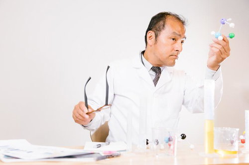 分子構造モデルを手に取り理解を深める男性科学者