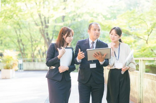 屋外でタブレットを使いながらジョブトレーニングする上司と部下