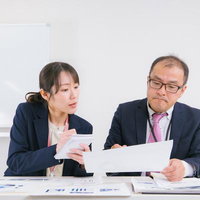 真剣な表情で業務内容を検討する上司と部下の写真