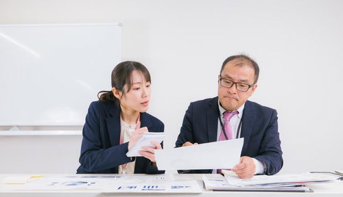 真剣な表情で業務内容を検討する上司と部下