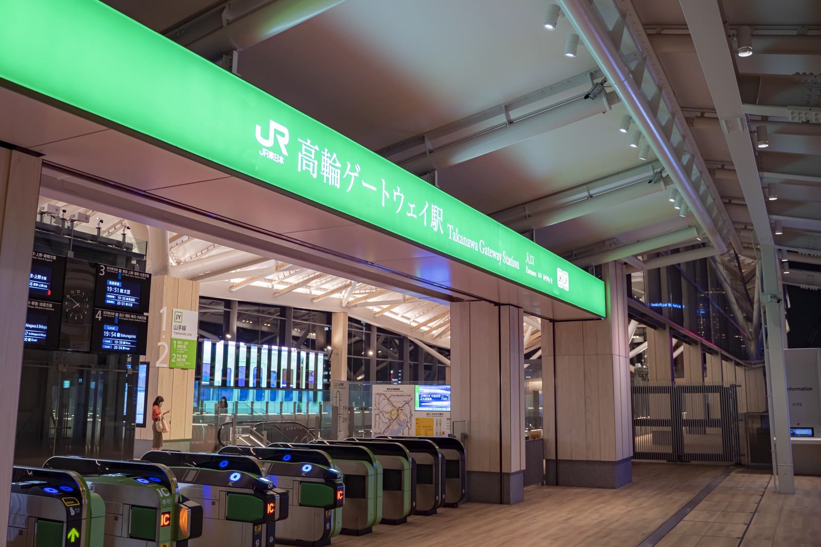 緑色の照明が点灯した高輪ゲートウェイ駅の改札エリア