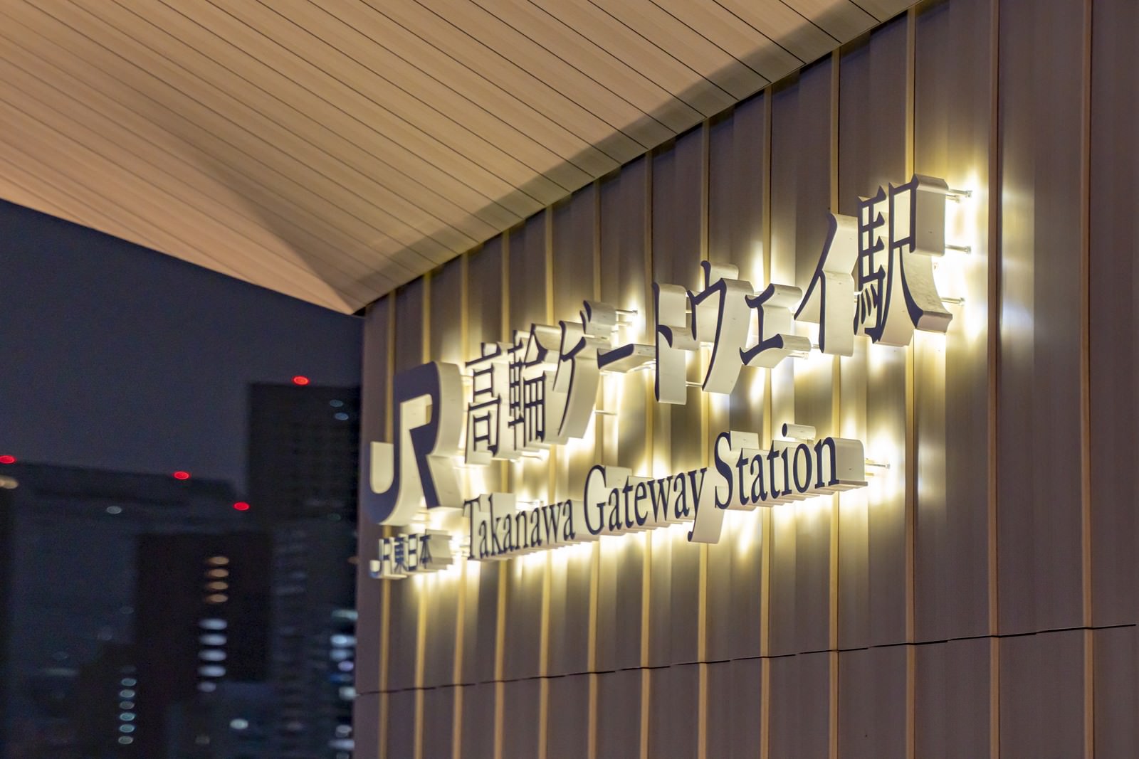 暖かい光でライトアップされた高輪ゲートウェイ駅の看板