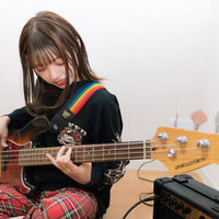 指弾きするベーシストの女性の写真