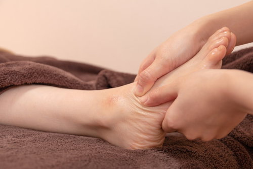 足の血行を良くするマッサージを受ける女性