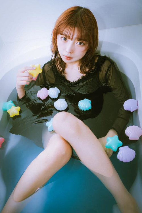 浴槽に浸かるカラフルなバスボムに囲まれた女子